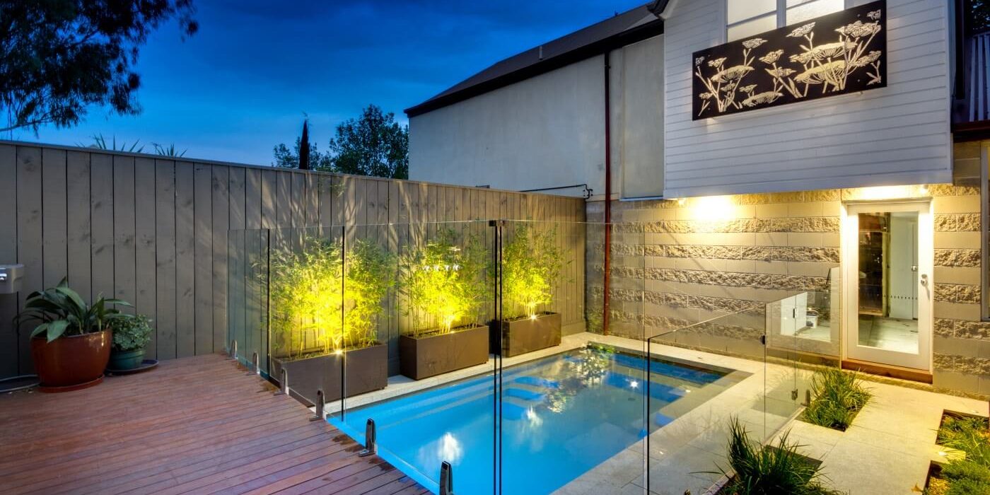 Modern backyard pool remodeling project with sleek composite decking and turf panels in Whitney NV