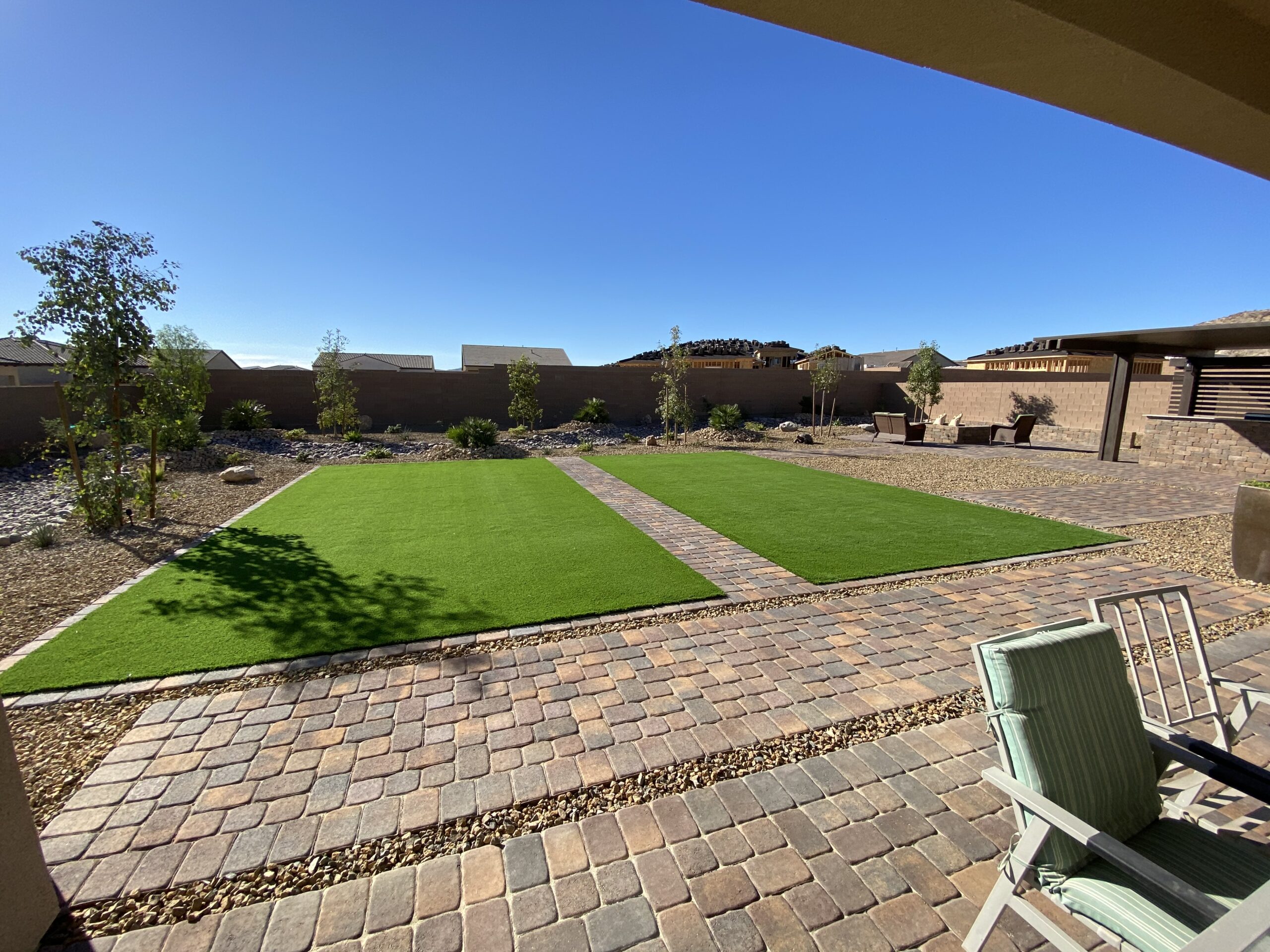 Lush, water-conserving front yard with artificial grass, decorative desert gravel and low-water plants