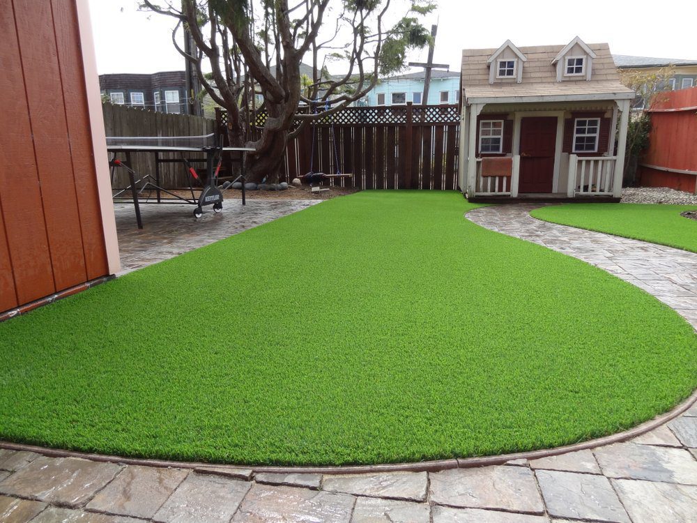 Premium artificial grass installation around a custom playhouse in a Las Vegas backyard